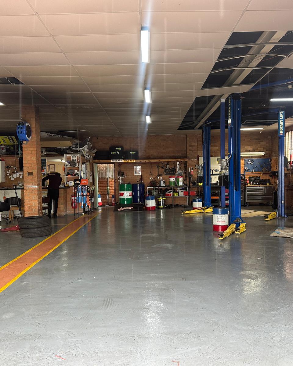 The 5AB workshop floor in Queanbeyan West, with blue two-post hoists and the service counter