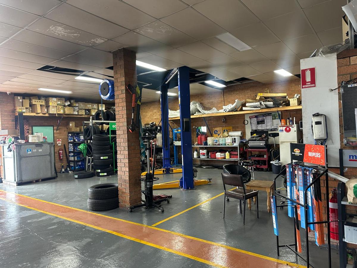 New tyres stacked beside a hoist and parts shelving in the 5AB workshop